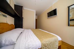 a bedroom with a bed and a flat screen tv at Porto Romantico 2 in Sveti Juraj