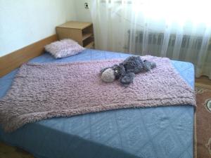 two stuffed animals laying on top of a bed at Guest House Kachaka in Pleven