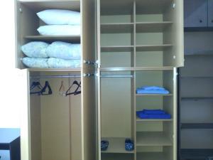 un armario con estantes blancos y toallas en Guest House Kachaka en Pleven