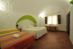 a hotel room with two beds and a window at Cuevas La Chumbera in Benalúa de Guadix