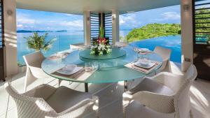 a dining room with a glass table and chairs at Ocean's 11 Villa in Ban Pa Khlok