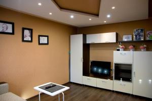 a living room with a tv and a white cabinet at Express Apartments Mira 110 in Berezniki