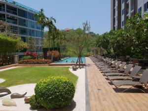 a row of chairs and a pool in a building at Unixx by GL in Pattaya South