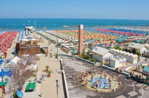 a beach with a crowd of people and the ocean at Hotel Astra in Cattolica