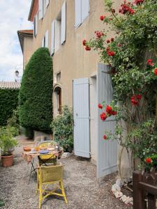 einen Garten mit einem Tisch und Stühlen sowie ein Gebäude in der Unterkunft "Le Château" in La Roche-des-Arnauds