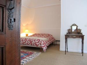 a bedroom with a bed and a table with a mirror at "Le Château" in La Roche-des-Arnauds