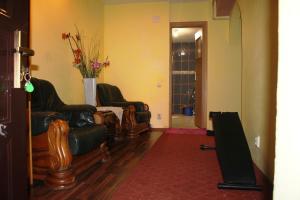 una sala de estar con 2 sillas y un jarrón de flores en Vitan modern apartment, sleeps 4, en Bucarest