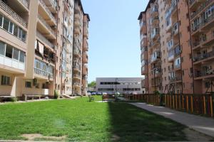 una zona de césped entre dos edificios de apartamentos en Vitan modern apartment, sleeps 4, en Bucarest