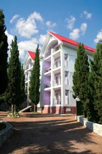 un gran edificio blanco con techo rojo en Hotel Lidia, en Alushta