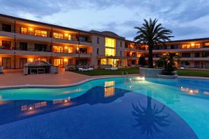 a large swimming pool in front of a building at Aparthotel Golf Beach in Pals