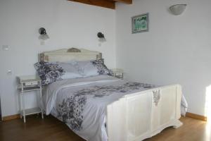 ジョンザックにあるLa Pommeraieの白いベッドフレームが備わる客室のベッド1台分です。
