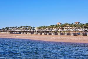 una playa con una fila de sombrillas y el océano en Jaz Mirabel Resort en Sharm El Sheikh