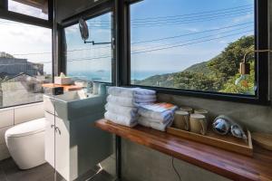 a bathroom with a sink and a toilet and a window at H& Jiufen Ore Inn in Jiufen