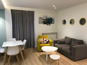sala de estar con sofá, mesa y sillas en Apartamentos Apolo, en Madrid