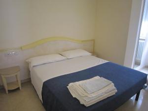 a bedroom with a bed with two towels on it at Hotel Astra in Cattolica