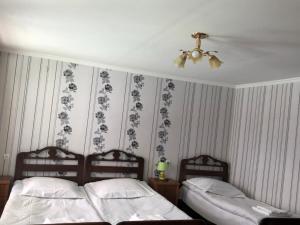 1 dormitorio con 2 camas y ventilador de techo en Lia&Ramaz Guest House, en Kazbegi