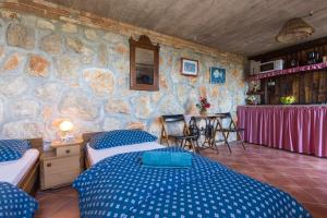 a bedroom with two beds and a stone wall at The View Studio Moscenice in Mošćenice