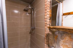 a shower in a bathroom with a stone wall at The View Studio Moscenice in Mošćenice