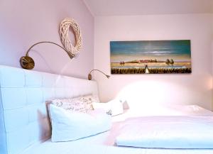 1 dormitorio con 1 cama y una pintura en la pared en Darssmuschel Dierhagen-Strand - Haus 2, en Dierhagen