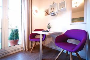 2 sillas y una mesa en una habitación con ventana en Darssmuschel Dierhagen-Strand - Haus 2, en Dierhagen
