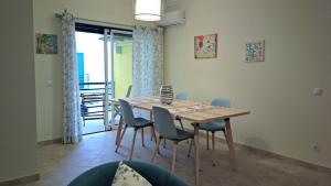 Un comedor con mesa y sillas y un balcón. en Santa Luzia Dream, en Santa Luzia