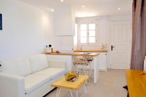 a living room with a white couch and a table at Lindos SeaSide Suite in Lindos