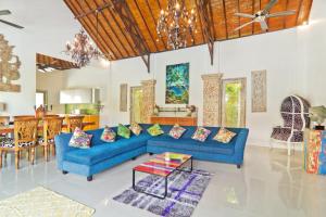 a living room with a blue couch and a table at Bamboo Moon Villas in Sanur