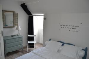 a bedroom with a bed and a dresser and a mirror at L'ESCALE in Allenay
