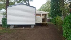 a tiny house in a yard with a shed at Mobile Home dans Domaine de Kerlann in Pont-Aven
