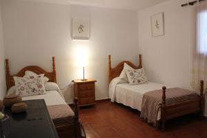a bedroom with two beds and a lamp on a table at La Villa in Mogán +19 photos