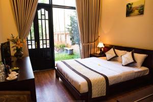 um quarto com uma cama e uma grande janela em Spring Garden Villa em Hue