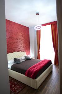 1 dormitorio con 1 cama con pared roja en Royal Termini, en Roma