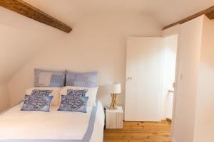 トゥルヴィル・シュル・メールにあるVilla Panamaのベッドルーム1室(青と白の枕が備わるベッド1台付)