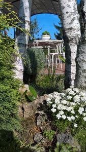 un giardino con tavolo, sedie e fiori bianchi di Il Girasole a Strevi