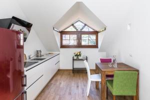 a kitchen with a wooden table and a kitchen with a window at Villa Anita Rooms in Bolzano