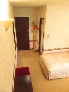 una camera con letto e porta per un bagno di Nikko Pension L'escale a Nikko