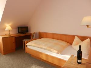 a bedroom with a bed with a bottle of wine on a table at Landhaus Braband in Cuxhaven