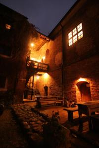 een oud bakstenen gebouw met een bankje er 's nachts voor bij Zamek Reszel in Reszel
