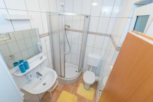 a bathroom with a shower and a toilet and a sink at Sun studio apartman in Zadar