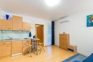 a kitchen with a table and chairs in a room at Sun studio apartman in Zadar