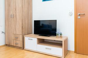 a living room with a television on a white cabinet at Sun studio apartman in Zadar