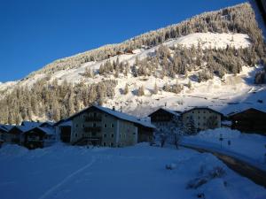 un lodge de esquí en la nieve con una montaña en Ferienwohnungen Steidl, en Innervillgraten