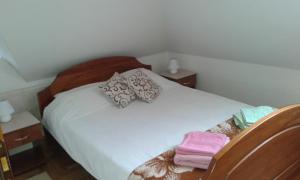 een slaapkamer met een bed met witte lakens en kussens bij Apartman Joca Zlatibor in Zlatibor