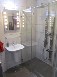 a bathroom with a sink and a glass shower at Konrado in Dziwnów