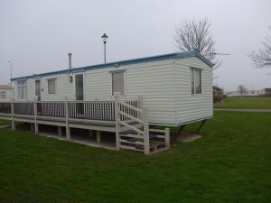 a mobile home with a porch and a deck at Mablethorpe L12 Caravan in Mablethorpe