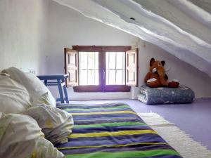 a teddy bear sitting on a pillow in a bedroom at Las Parras in Rute