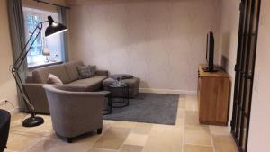 ein Wohnzimmer mit einem Sofa und einem TV in der Unterkunft De Friesenjung Nordsee in Risum-Lindholm