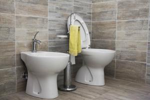 La salle de bains est pourvue de toilettes et d'une serviette jaune. dans l'établissement Casina Miriano, à Castiglione del Lago