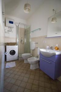 a bathroom with a sink toilet and a washing machine at La Marina House - Al Duomo in Catania