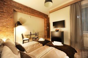 a bedroom with a bed and a brick wall at Apartmány Kukučín in Košice